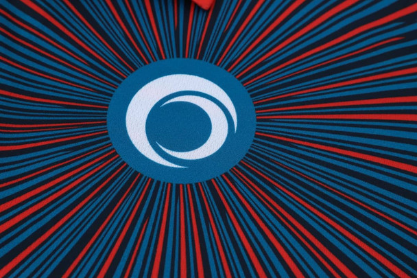 A vibrant blue and red sublimated sport polo featuring a circular logo at the centre.