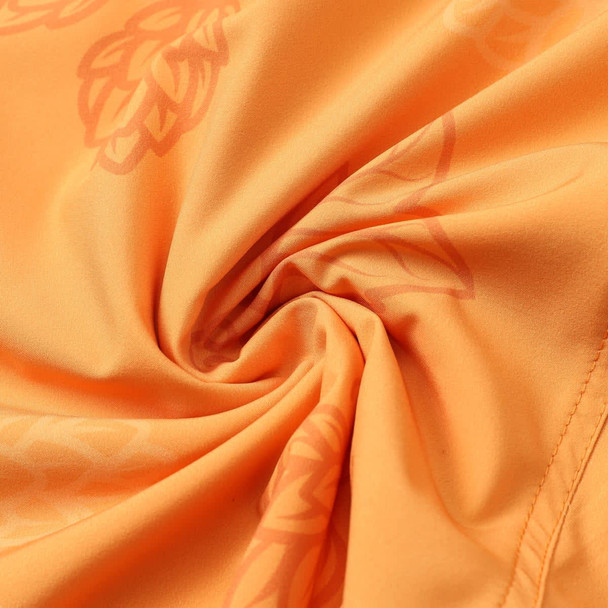 An orange fabric featuring a subtle leaf pattern, suitable for athletic wear, with a smooth texture. An orange fabric featuring a subtle leaf pattern, suitable for athletic wear, with a smooth texture.