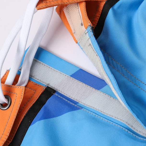 Knee-length swim shorts in vibrant blue and orange with a drawstring waist and a logo. Knee-length swim shorts in vibrant blue and orange with a drawstring waist and a logo.