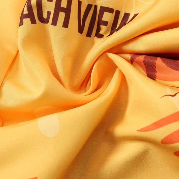 A close-up of yellow polyester fabric with a vibrant, abstract pattern and a logo.