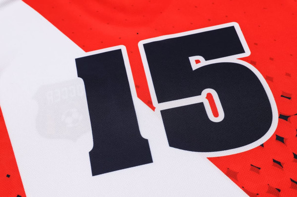 A close-up of a red and white football jersey featuring the number 15 and a logo.