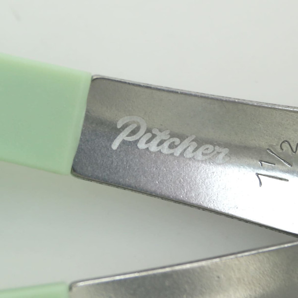 A set of measuring spoons with green handles and metal heads, featuring an engraved logo on the metal.