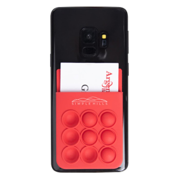 A red silicone phone wallet featuring popper stress reliever bubbles attached to a smartphone with a card inserted.