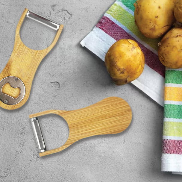A drink bottle opener and peeler made from bamboo, featuring a metal bottle opener and surrounded by potatoes and a striped cloth.