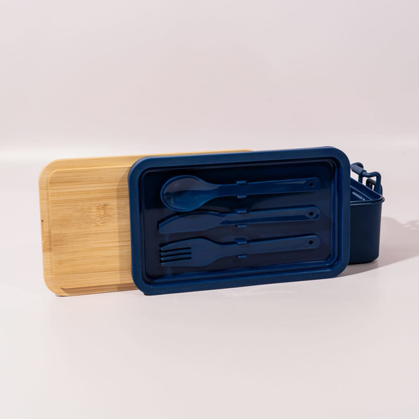 A navy blue lunch box with a bamboo lid and utensils, including a spoon and fork, included inside.