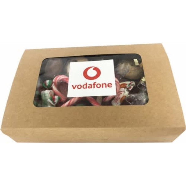 A kraft gift box filled with assorted confectionery, visible through a clear window, featuring a logo on the front.