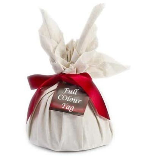 A wrapped Christmas pudding in cream fabric with a red ribbon, featuring a tag.