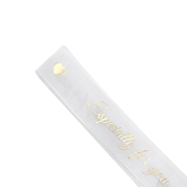 A sheer white organza ribbon featuring gold lettering and embellishments. Includes a heart design.