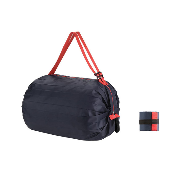 A foldable shopping shoulder bag in navy blue with red straps, featuring a compact foldable design.
