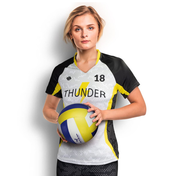 A woman holds a volleyball while wearing a custom women's volleyball top in black, white, and yellow with a logo. A woman holds a volleyball while wearing a custom women's volleyball top in black, white, and yellow with a logo.