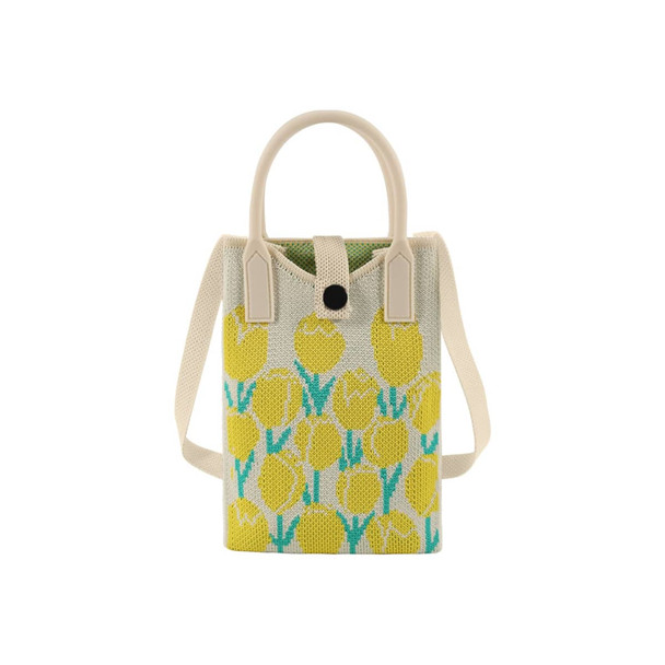 A knitted phone crossbody bag in white with a yellow tulip pattern and lightweight handles. Features a logo on the side.