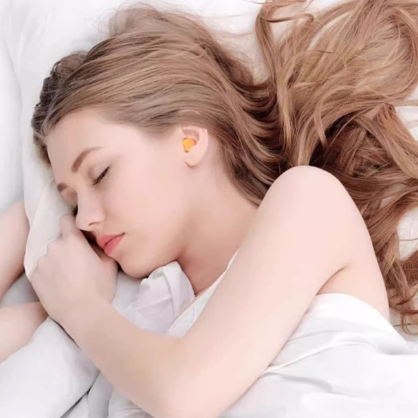 A young woman with long hair sleeps peacefully, wearing bright yellow ear plugs in her ears.