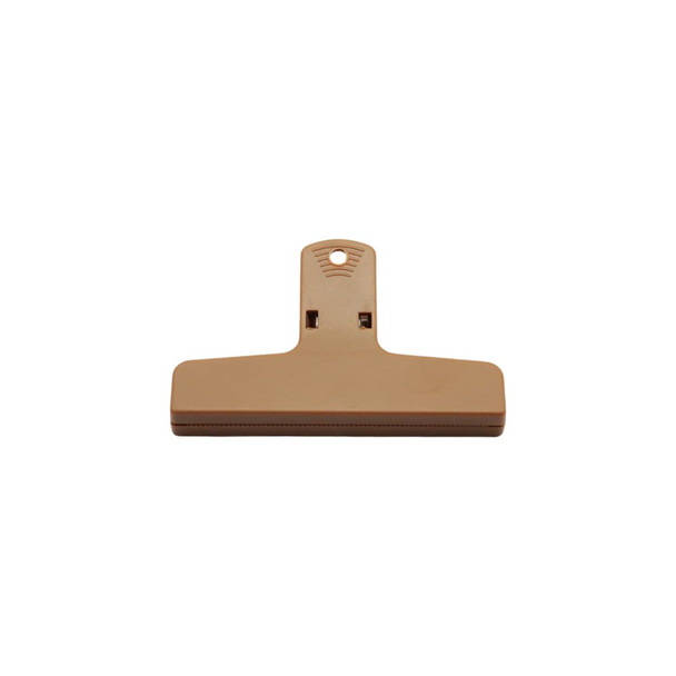 A tan plastic magnetic clip with a large flat surface and a hanging hole for easy storage.