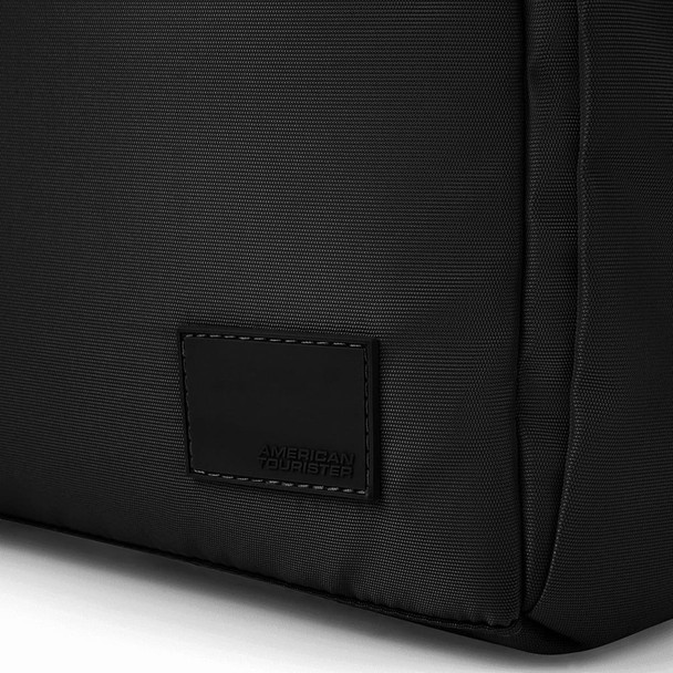 A black duffle bag with a smooth texture and a branding label on the side.
