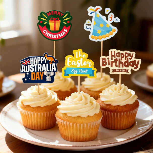 A tray of cupcakes topped with cream frosting, decorated with colourful party-themed toothpicks.