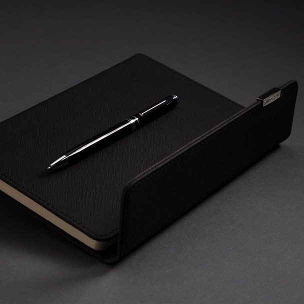 A black A5 notebook with a matching black pen, featuring a subtle logo on the notebook cover.