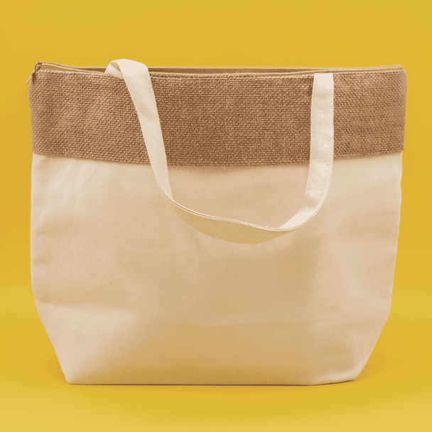 A jute and cotton cooler bag in cream with a brown jute top and white straps, featuring a logo.