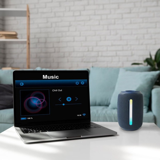 A blue outdoor waterproof Bluetooth speaker sits next to a laptop displaying a music player interface.