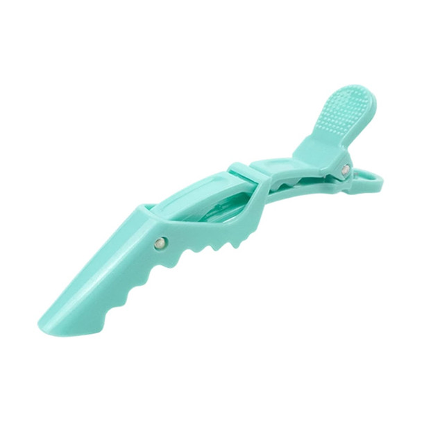 A turquoise alligator clip with an anti-slip grip feature and a textured top for secure holding.
