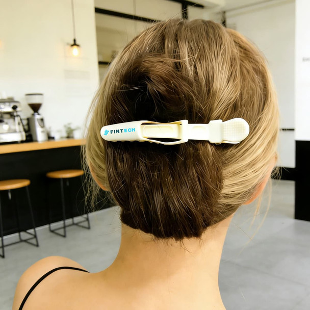 A hair clip in white and yellow, styled in a person's hair, featuring a logo.