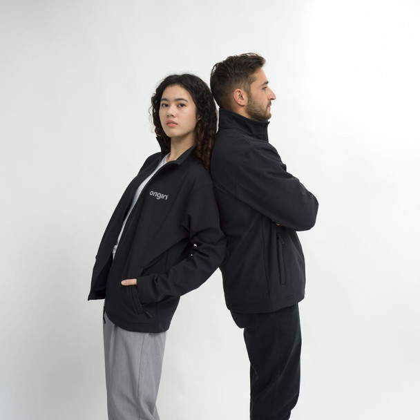 A black unisex soft shell jacket worn by two individuals standing back to back, with one having a logo on the front.