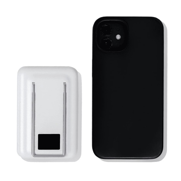 A white magnetic power bank with a phone stand next to a black smartphone. The power bank features a logo.