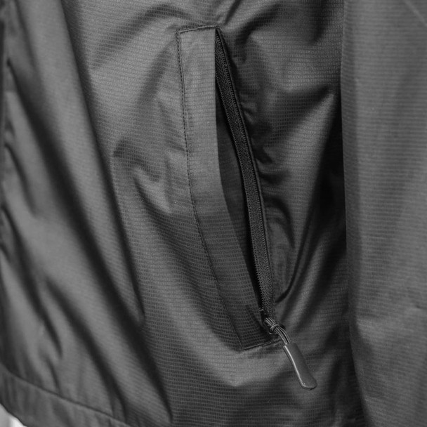 A close-up of a black TRENDSWEAR Wellington Unisex Windbreaker featuring a zippered pocket and soft shell fabric.