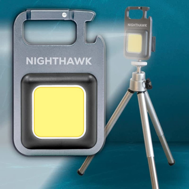 A grey Nighthawk COB LED multi-tool with a yellow light, positioned near a tripod. It features a logo.