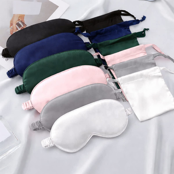 A collection of satin sleep masks in various colours, including navy, green, pink, grey, and white, with packaging.