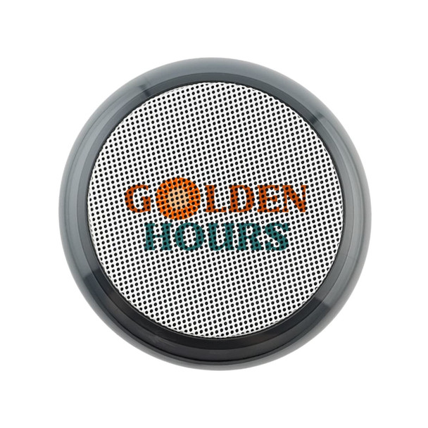 A round, black and silver speaker with a textured surface and a logo on the front.