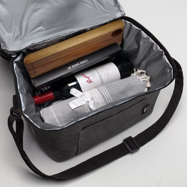 A grey cooler bag with a wine bottle, a wooden wine opener, and a rolled-up blanket inside. It has a logo.