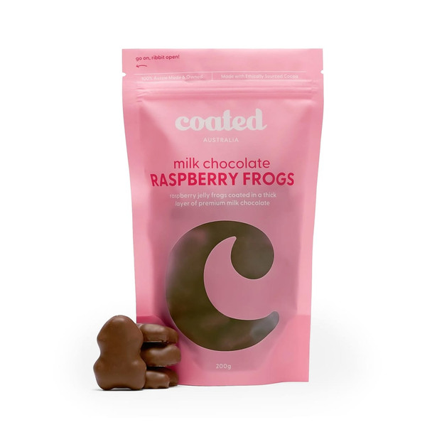 A pink bag of Coated Australia milk chocolate raspberry frogs with three chocolate-covered frogs in front.