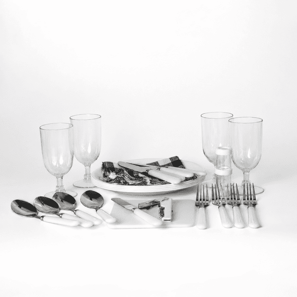 A picnic set features white-handled cutlery, glass tumblers, and serving platters on a white background.