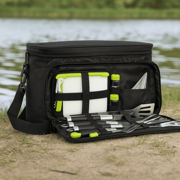 A black picnic bag with green accents, containing cutlery, a chopping board, drink bottles, and various food prep tools.