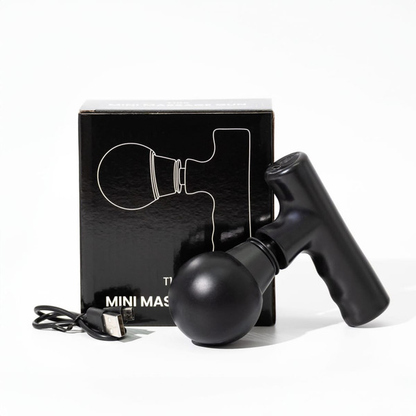 A black mini massage gun beside its box and a charging cable, featuring a sleek design and rounded head.