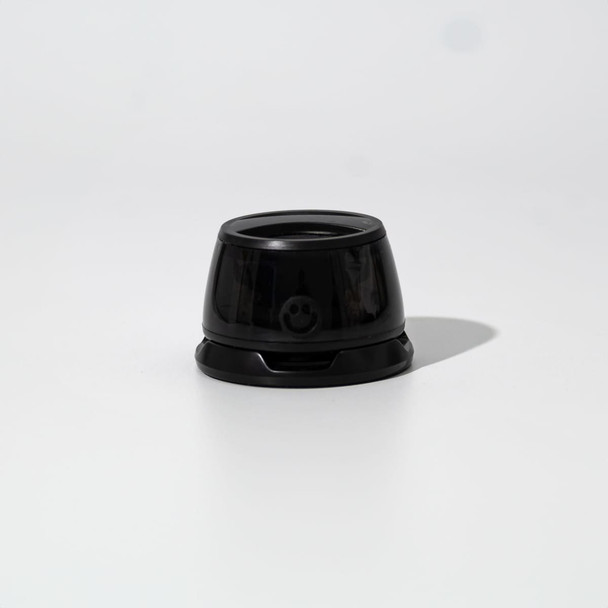 A black speaker with a rounded design, featuring a smooth surface and a small branding element at the front.