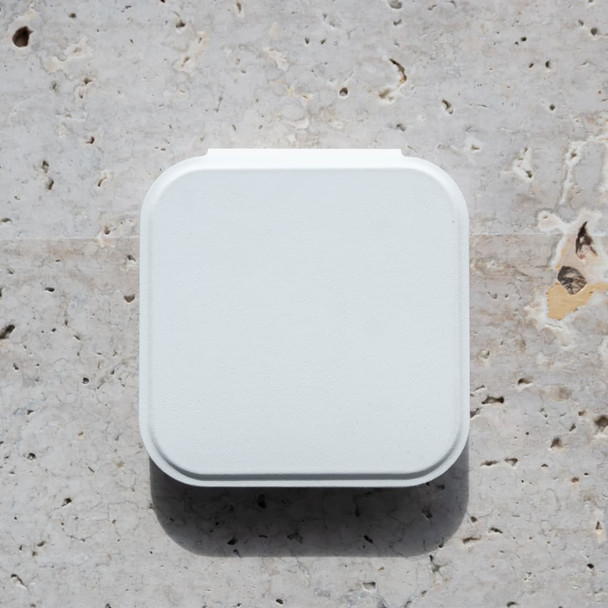 A white compact mirror with an LED light, featuring a square shape and a smooth surface, resting on a textured stone background.