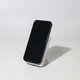 A black wireless charging power bank stands on a white base, showcasing its sleek design.