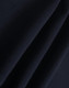 A close-up of dark navy polar fleece fabric showing soft, smooth texture folds. It features a branding logo.