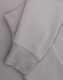 A light grey crewneck sweatshirt with a soft texture, featuring long sleeves and a cuffed hem.