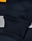 A close-up of a navy blue jumper with a striped design and ribbed cuffs, featuring a logo.