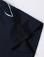 A navy blue polo shirt featuring short sleeves and contrasting stitching. It has a logo on the chest area.