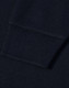 A close-up view of the cuff of a navy blue polo shirt featuring a ribbed design and a logo.