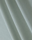 A close-up of light green cotton fabric, featuring a textured weave suitable for polo shirts.