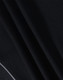 A close-up of textured black fabric, showcasing the material of a polo shirt. It has a logo detail.
