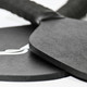 A black pickleball paddle and ball set with a textured grip, featuring a logo on one item.