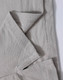 A close-up of a light grey polo shirt, showing the textured fabric and stitching details. The shirt features a logo.