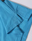 A close-up of a turquoise polo shirt, featuring a branded label and detailed fabric texture.