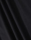 A close-up of black fabric showcasing the texture of a polo shirt. The material appears smooth and lightweight.