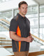 A men's short-sleeve polo shirt in charcoal grey with orange contrast stripes and a logo.